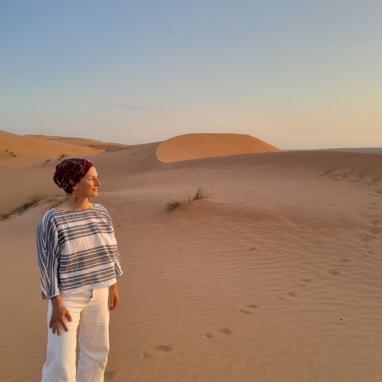 Lacy in sand dunes looking toward sunset