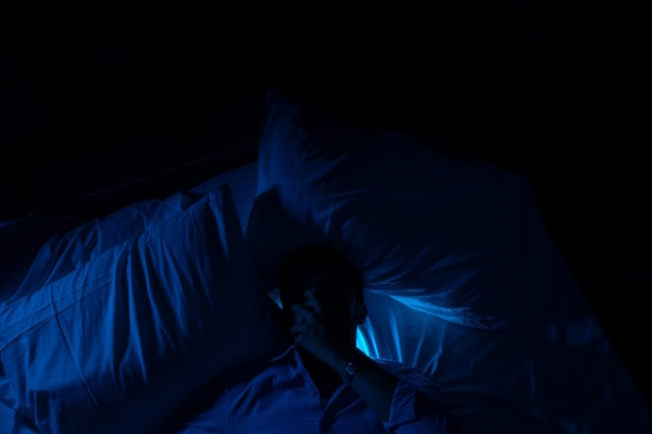 Person sleeping at night on back. Photo by Mohamed Jamil Latrach on Unsplash