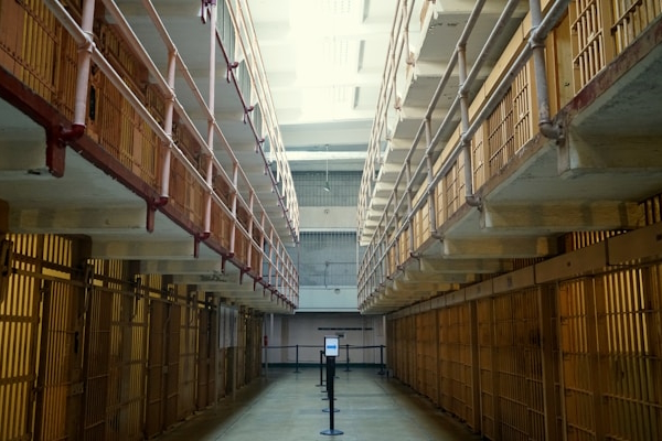 Inside prison with cells on either side of central hall. Photo by Tim Photoguy on Unsplash