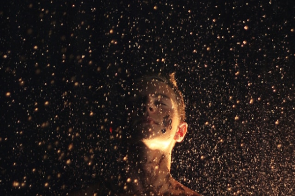 Person with eyes closed facing the falling rain. Photo by Christopher Campbell on Unsplash