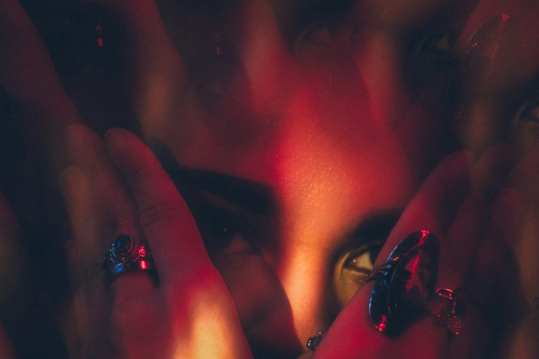 Person's face seen through kaleidoscope and shadow. Photo by Jeffrey Keenan on Unsplash 