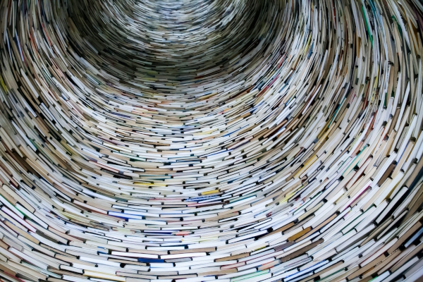 Vertical tunnel made of stacked books. Photo by Lysander Yuen on Unsplash
