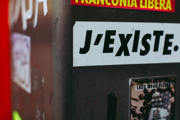 Sticker on wall, "J'ESISTE." Photo by Markus Spiske on Unsplash