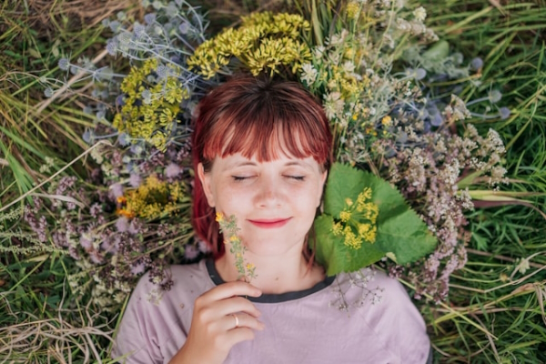 Woman lying down among wildflowers, content. Photo by Aleksandra Sapozhnikova